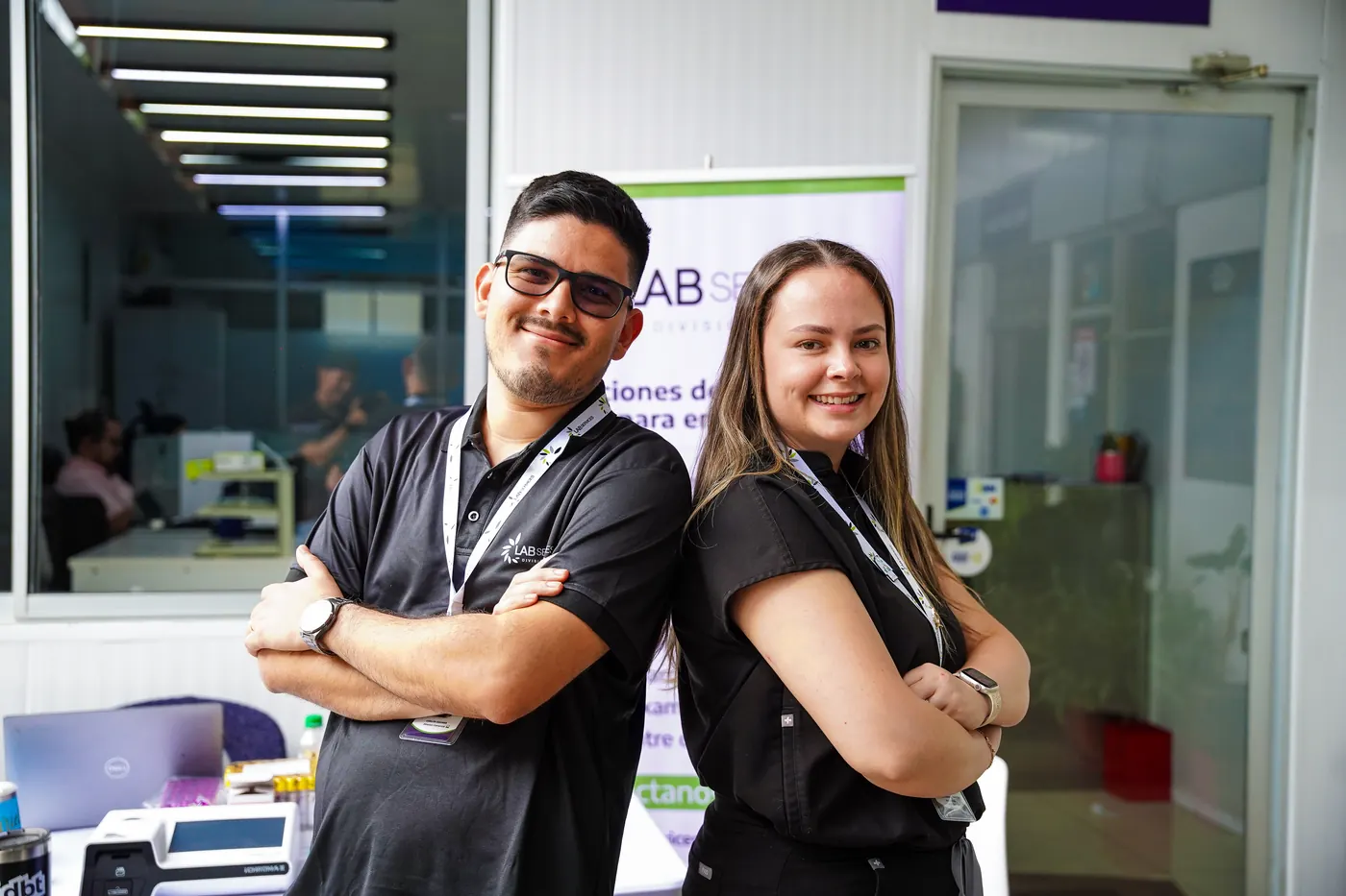 Dos profesionales del equipo de LabServices, con sus carnés, durante una jornada de salud en una empresa