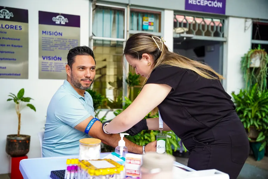 Colaborador sonriendo mientras le toman una muestra de sangre en la jornada