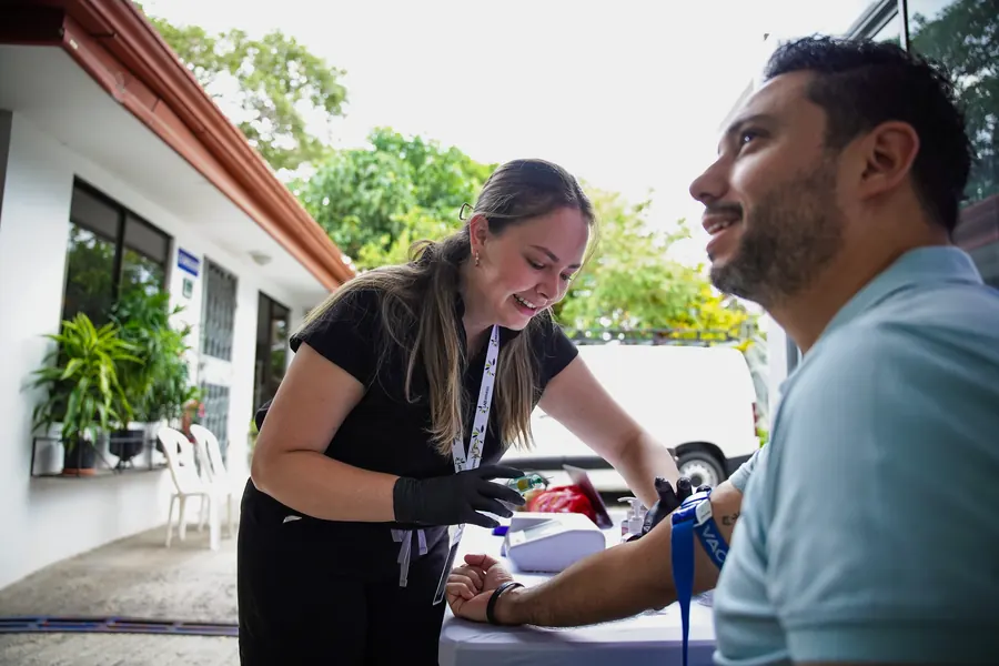 Profesional de LabServices tomando una muestra de sangre a un colaborador al aire libre